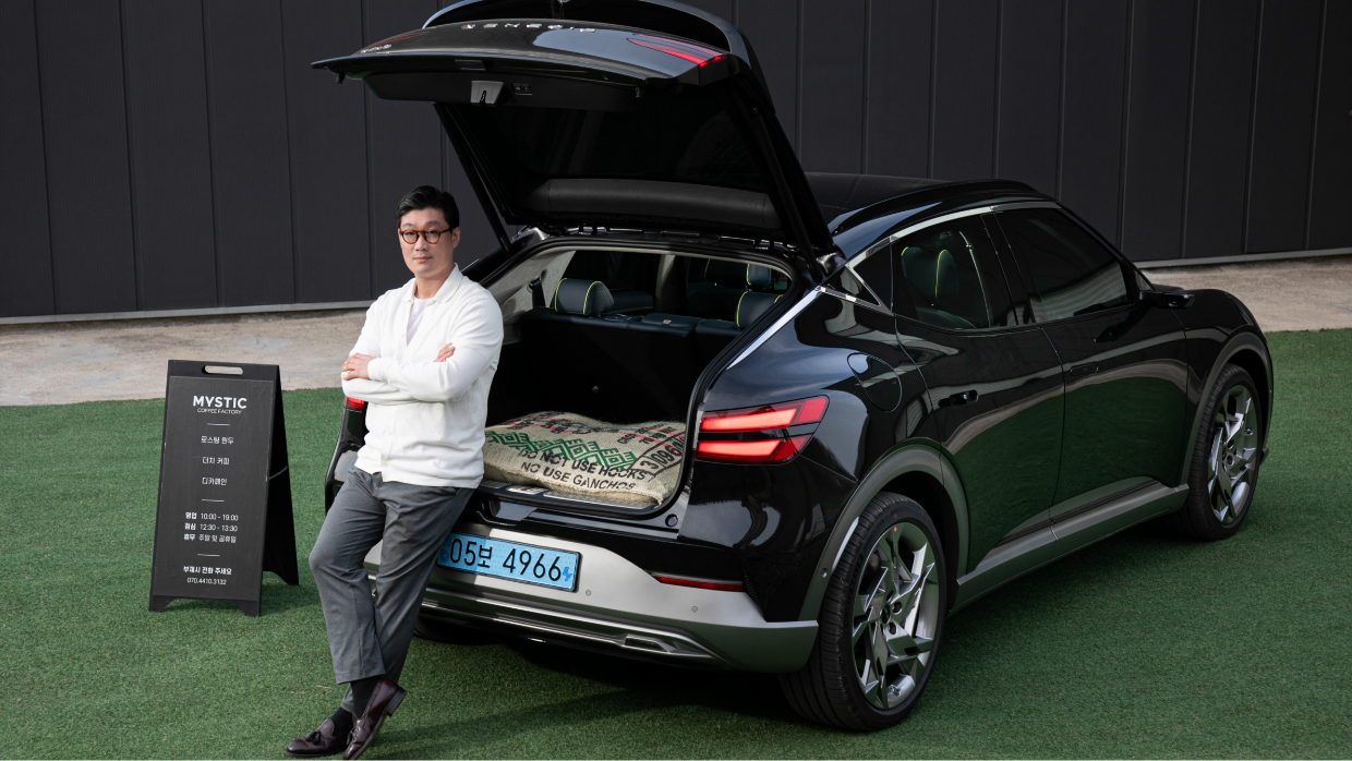 Model and interviewee Jang Woo-young sitting in the back of a GV60 with the trunk opened