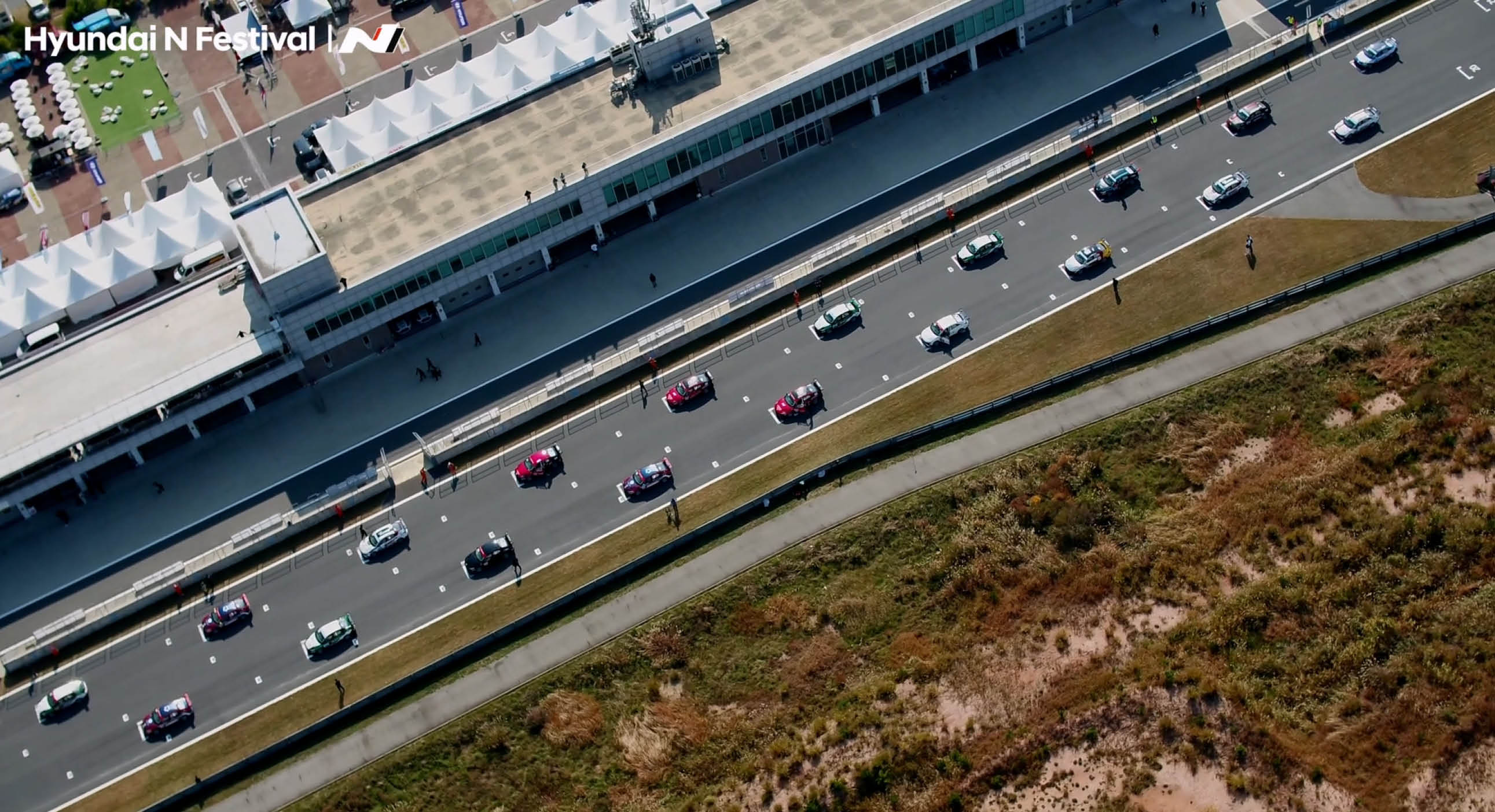 Drone shot of race cars on the track from the sky