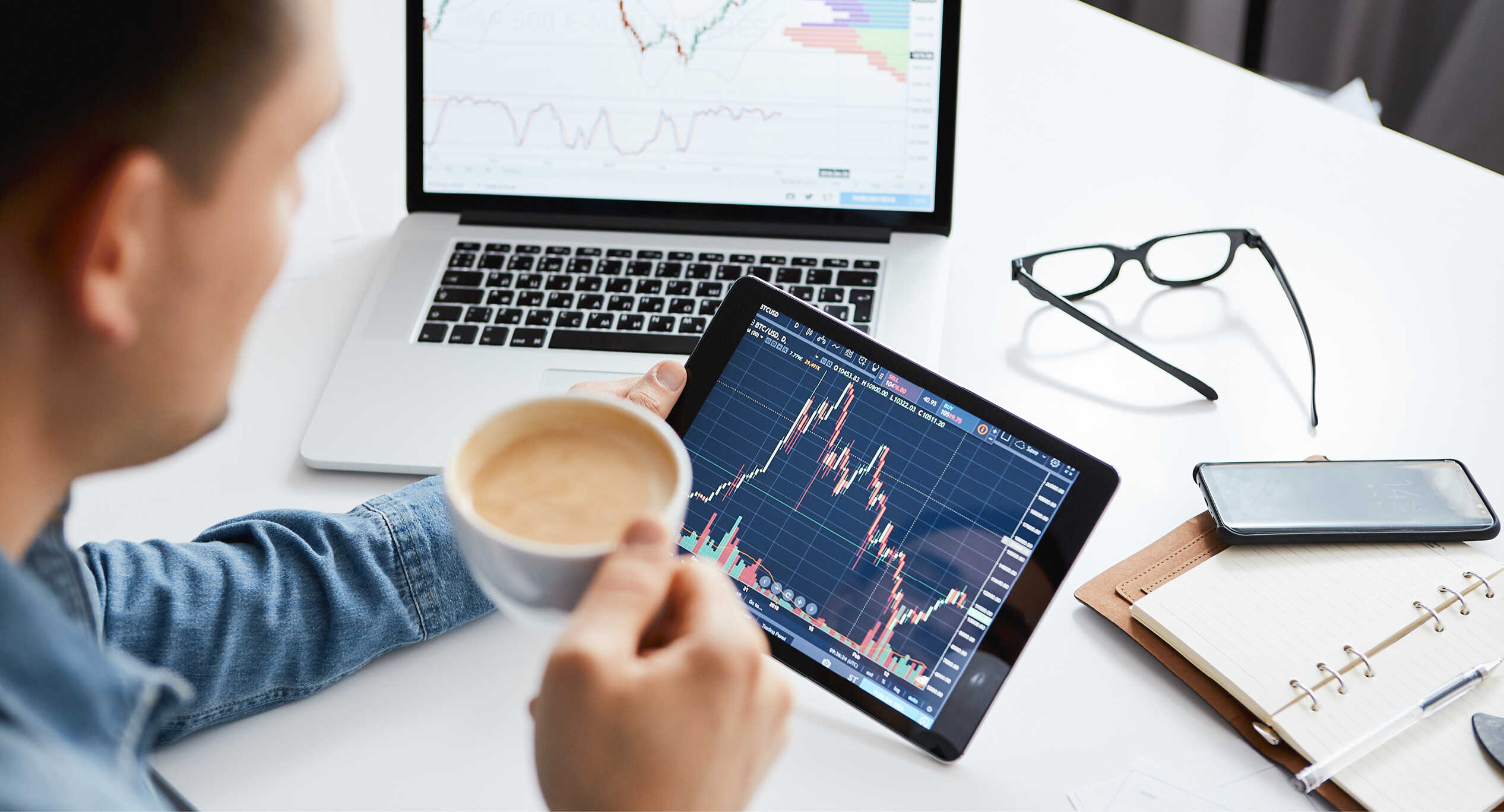 A Man Looking At A Stock Graph Over Coffee