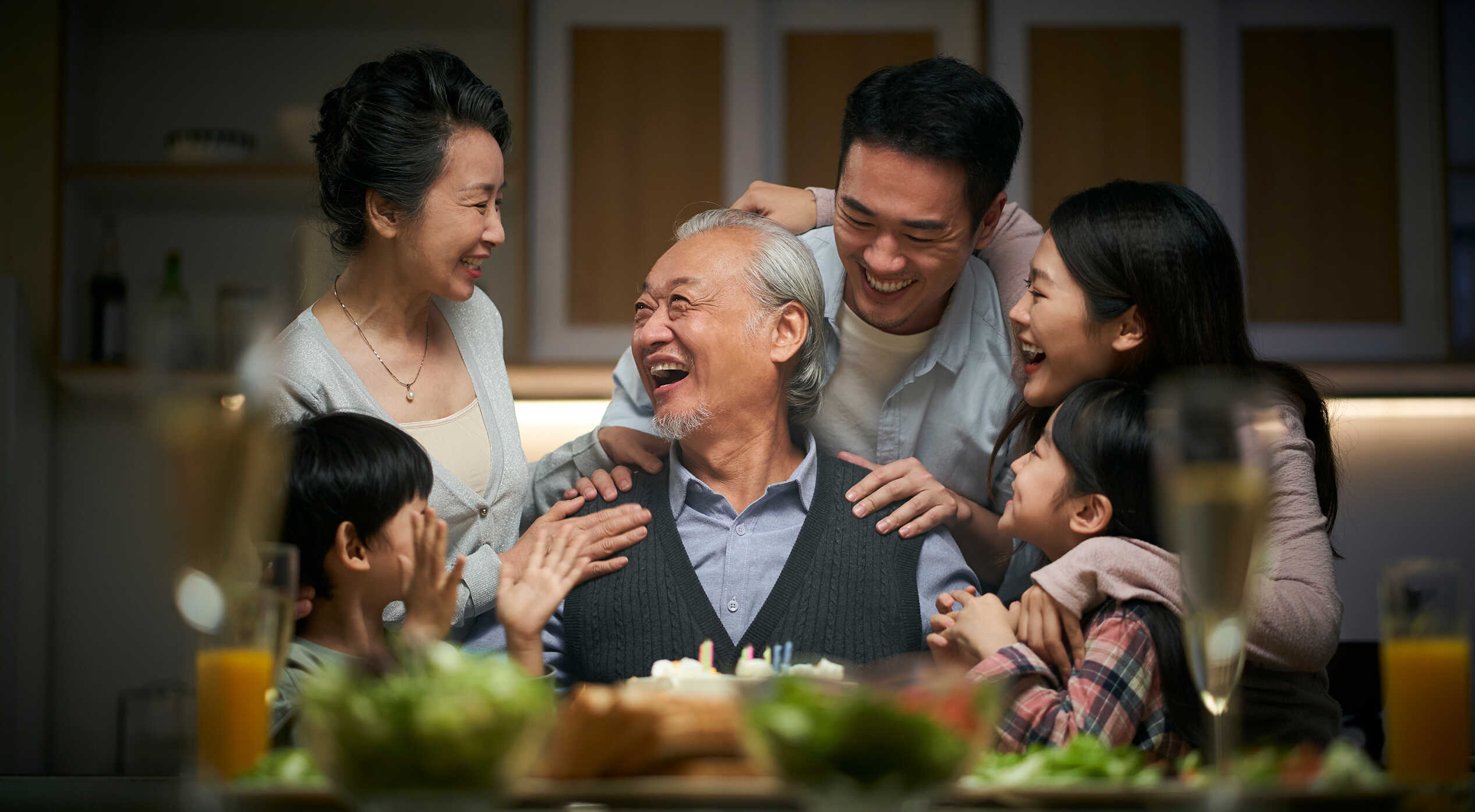 Three generations of families hugging each other and smiling
