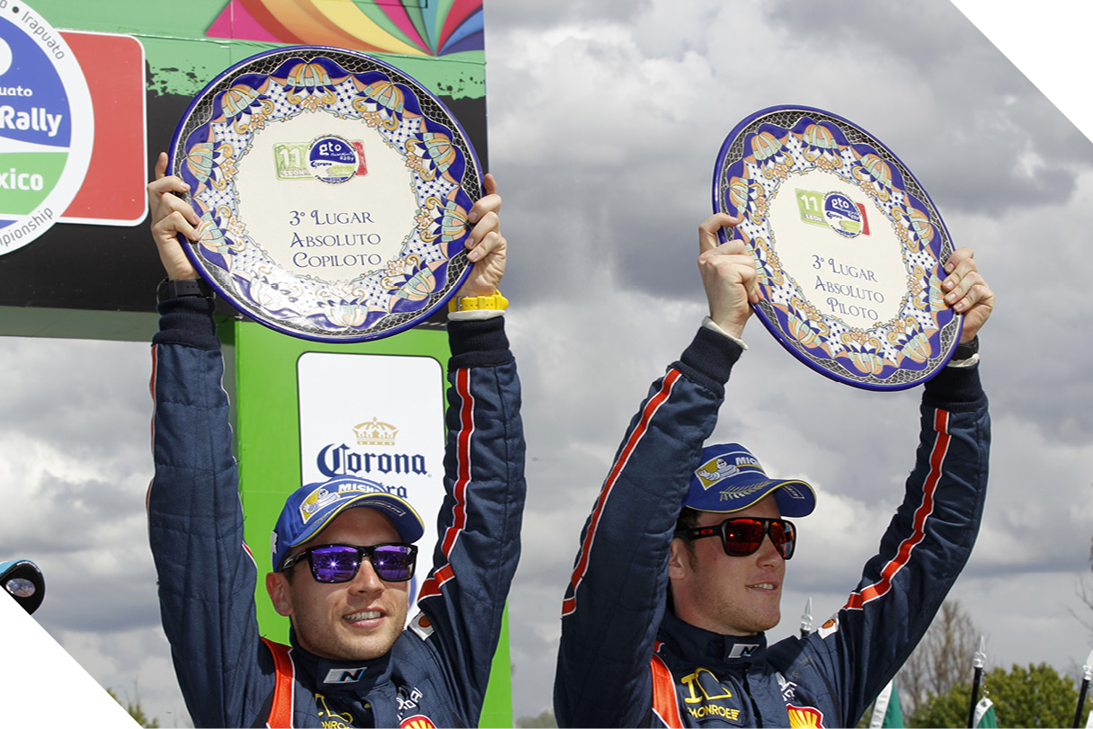 Two racers holding up a commemorative plaque