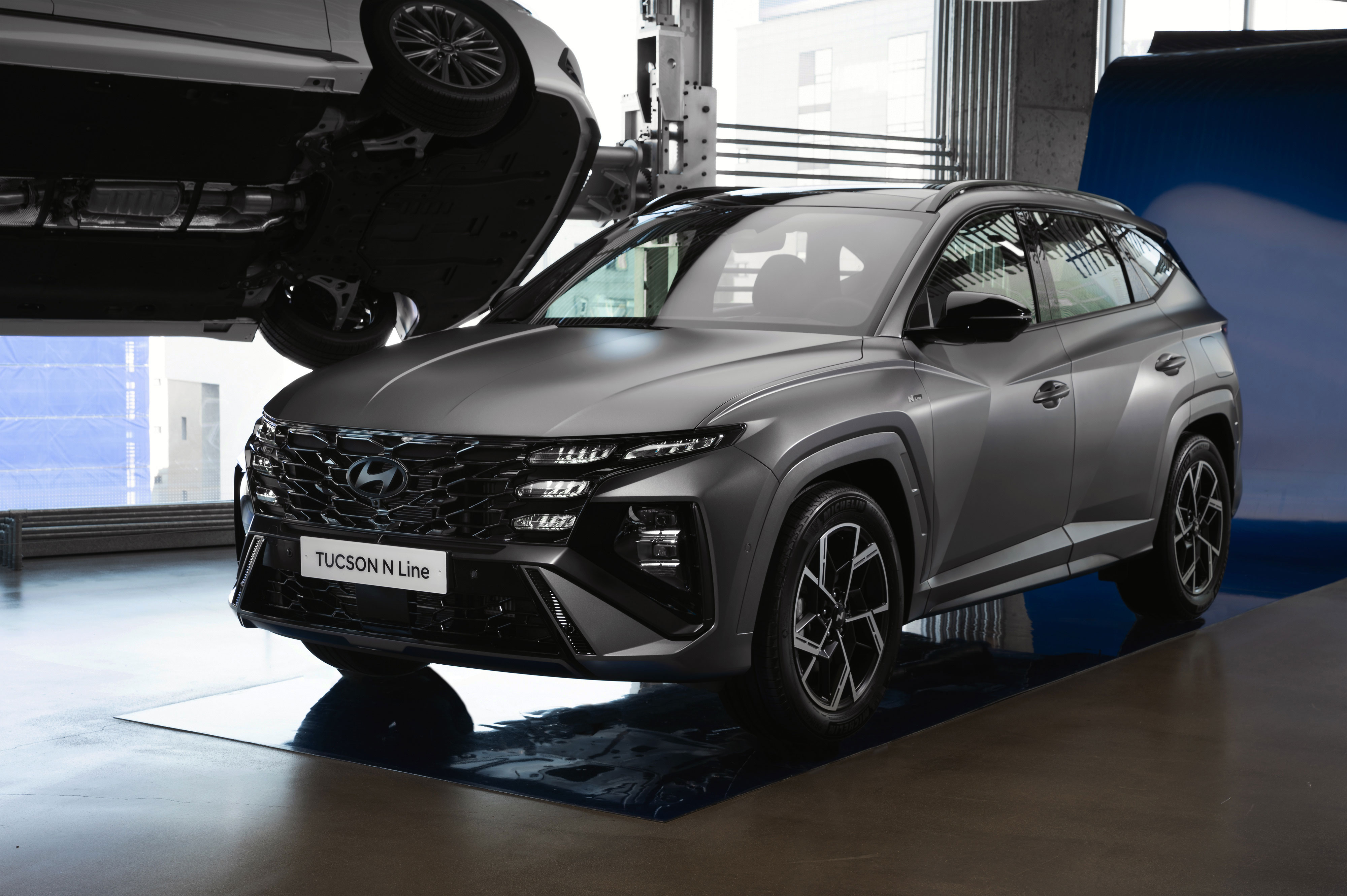 실내 전시 공간에 놓인 더 뉴 투싼 N Line SUV 정면