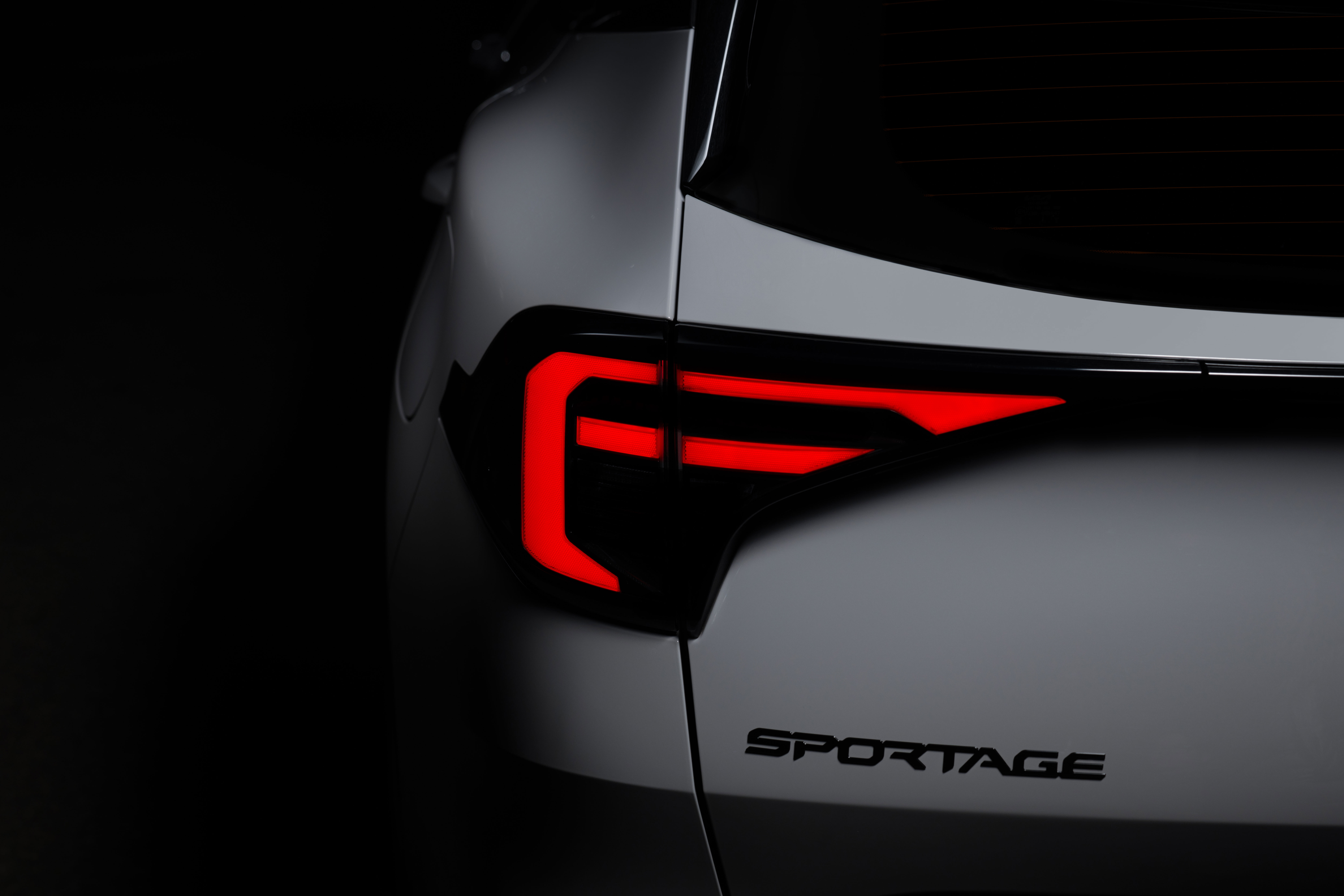 점등된 테일램프와 ‘SPORTAGE’ 엠블럼이 보이는 기아 스포티지 후면 부분 확대