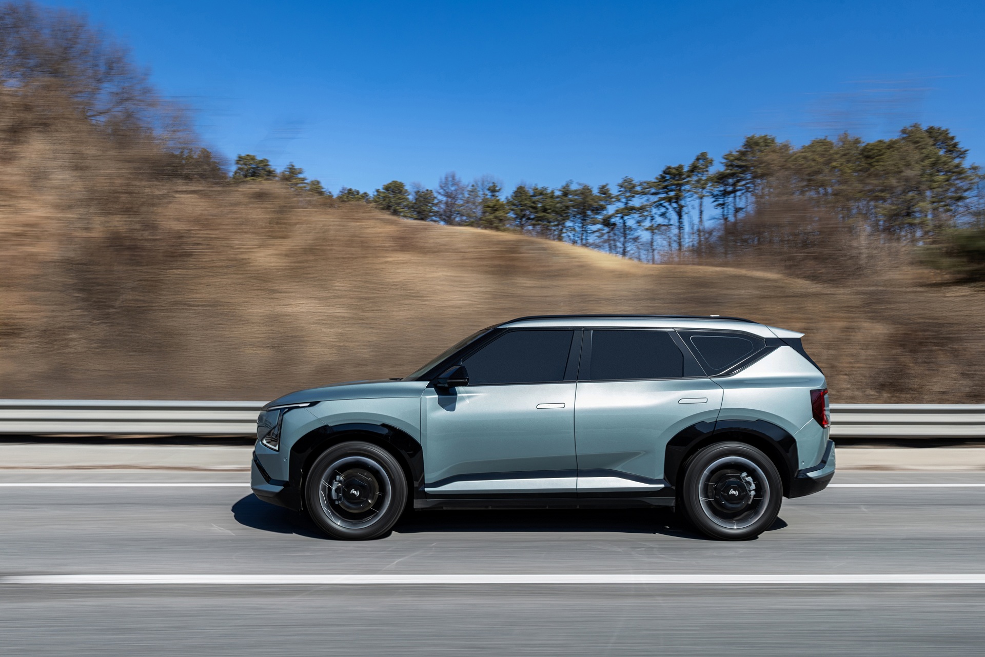 탁 트인 도로와 맑은 하늘 아래, 선명하게 드러나는 기아 EV5 GT-Line의 볼드한 실루엣.