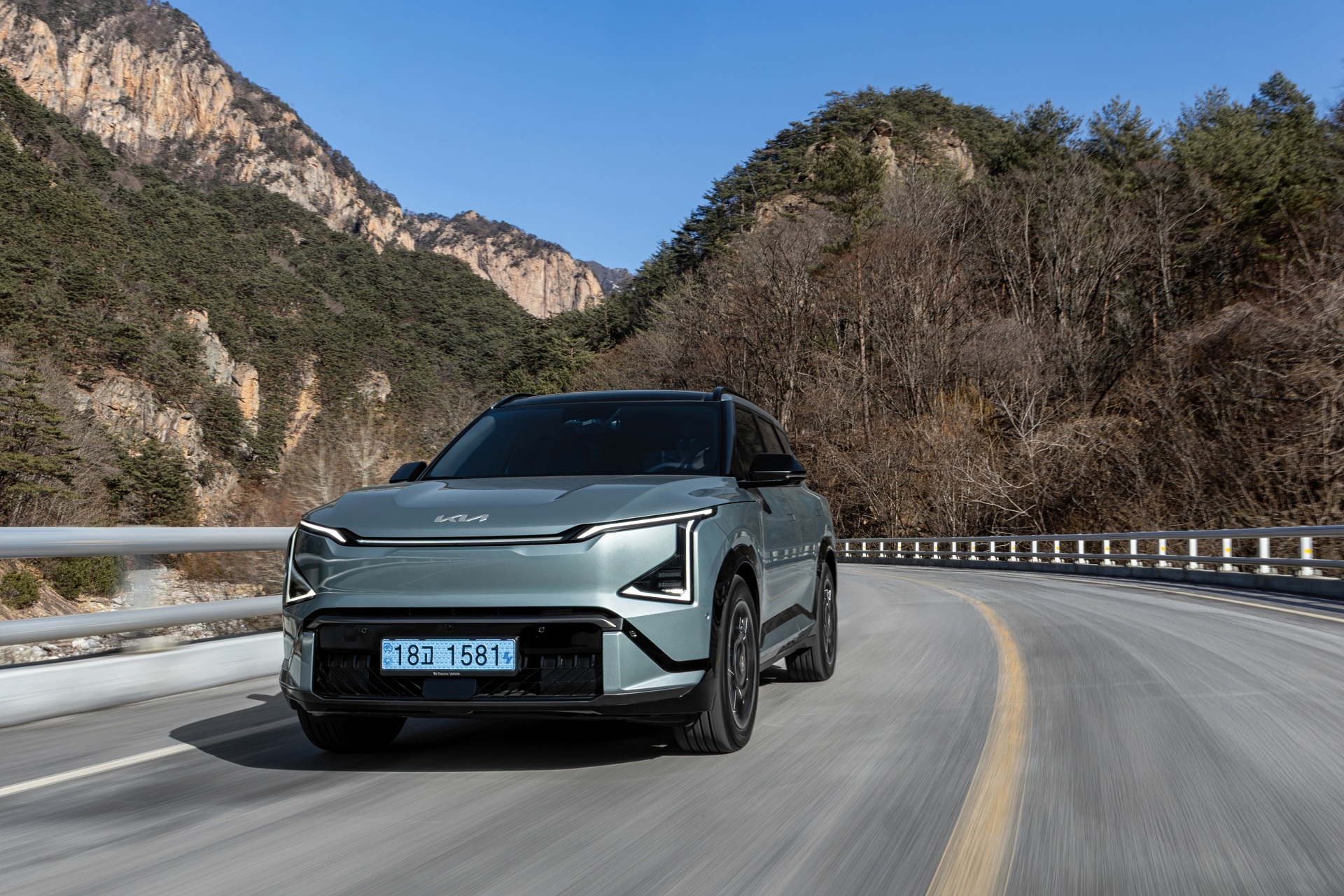 탁 트인 도로와 맑은 하늘 아래, 선명하게 드러나는 기아 EV5 GT-Line의 볼드한 실루엣.