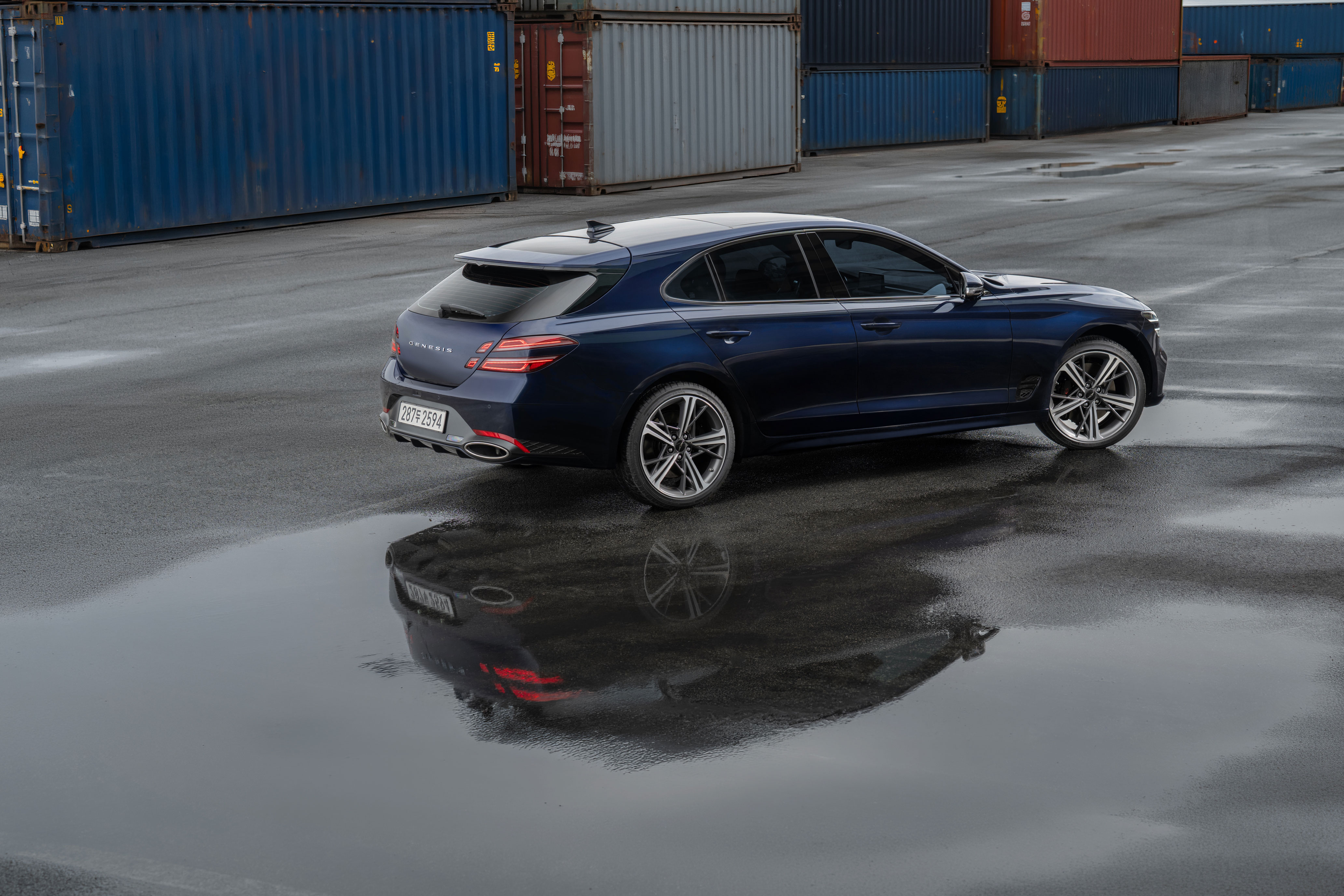 컨테이너 야적장 도로 위 제네시스 G70 슈팅브레이크 차량의 후측면