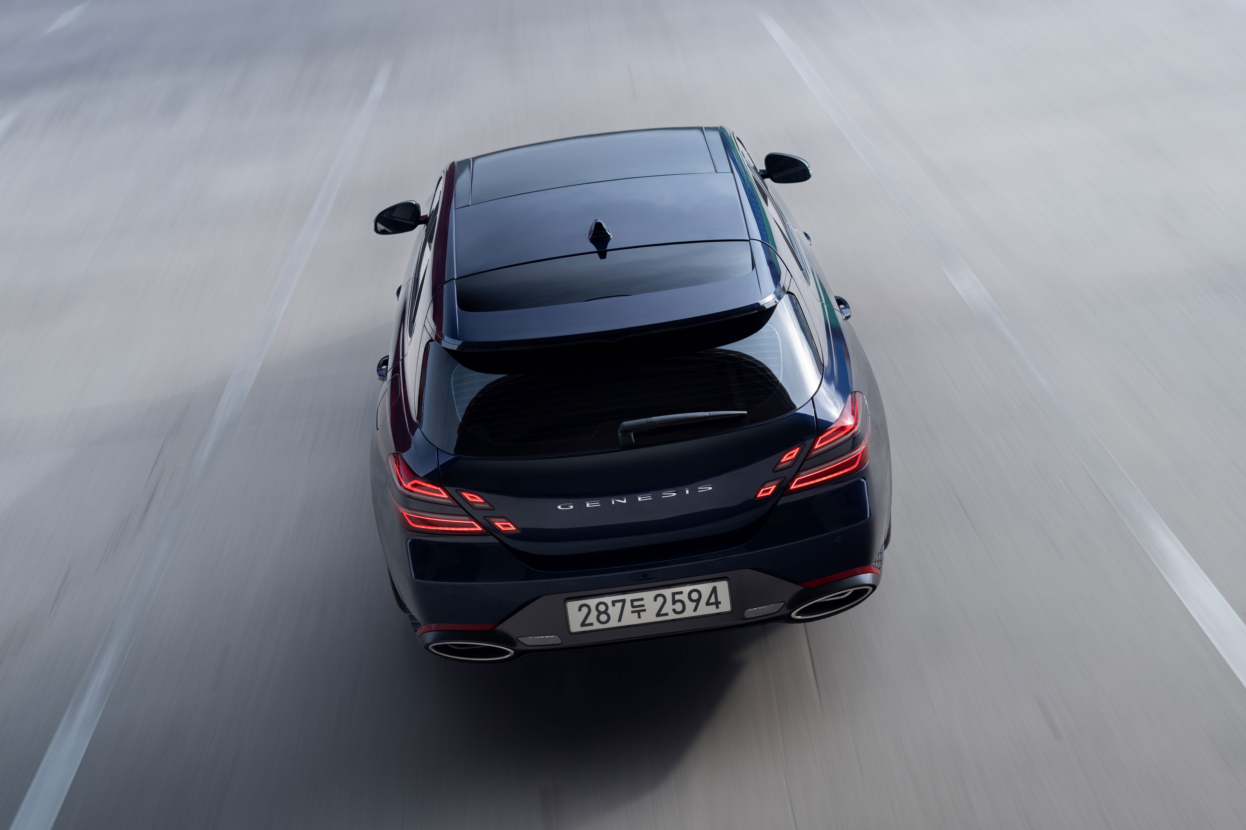 도로 위를 주행하는 제네시스 G70 슈팅브레이크 차량의 후면 상단