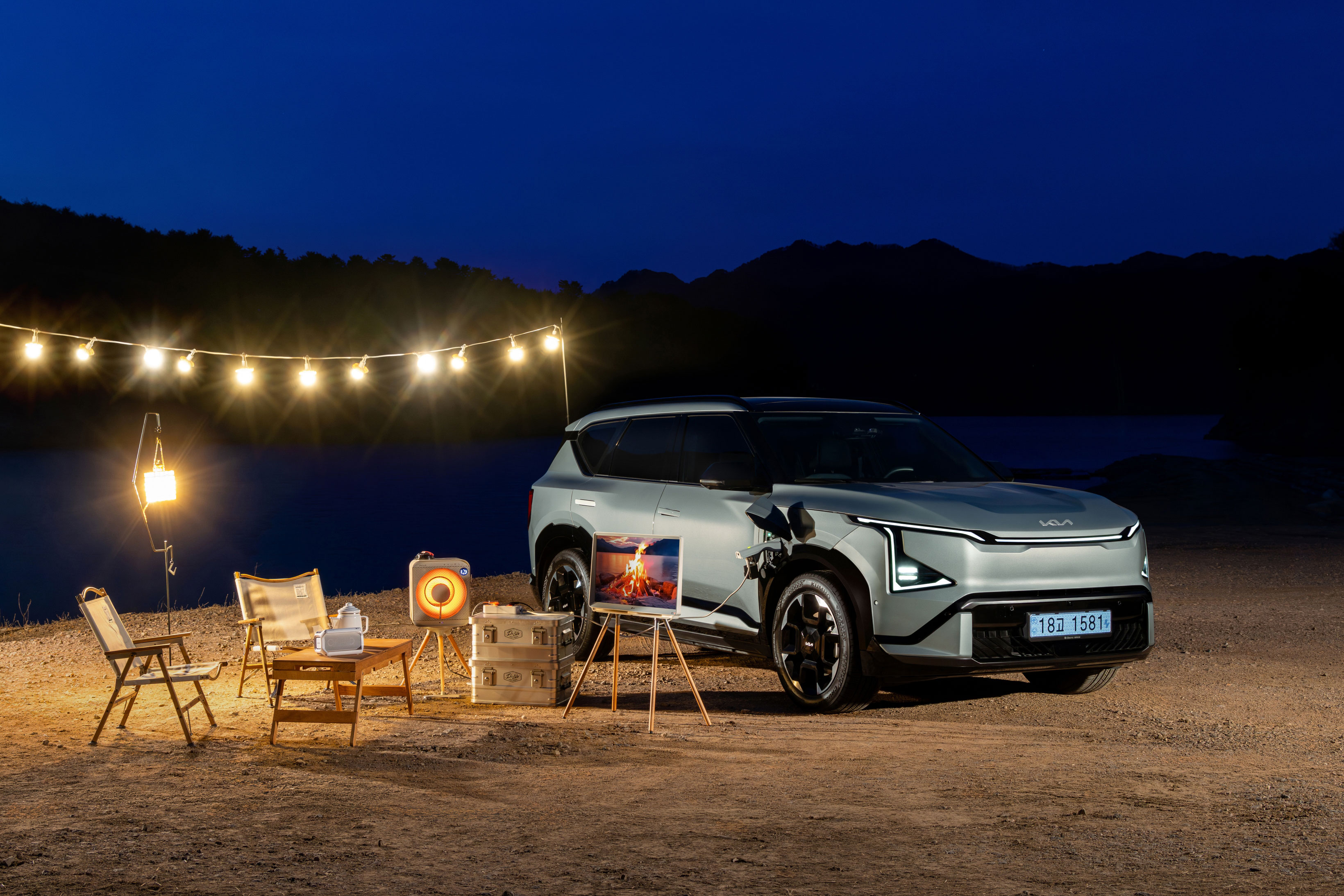 야간 호숫가 캠핑장에 주차된 기아 EV5 GT-Line 차량의 정측면