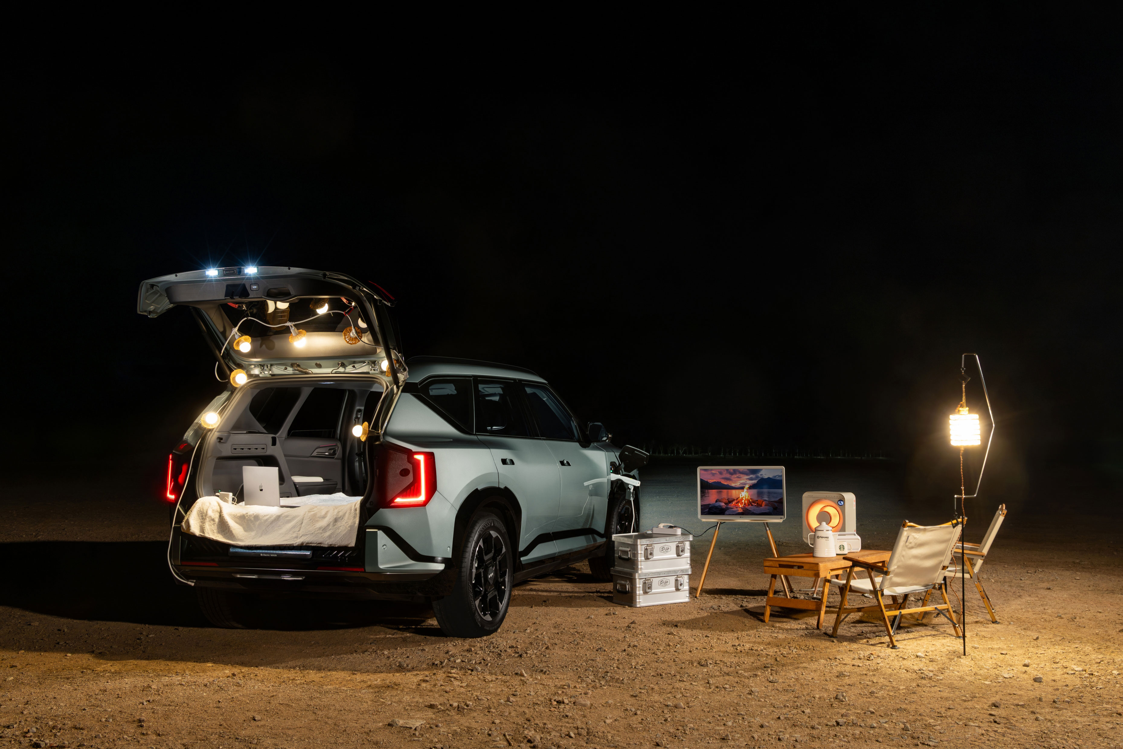 야간 호숫가 캠핑장에 주차된 기아 EV5 GT-Line 차량의 후측면