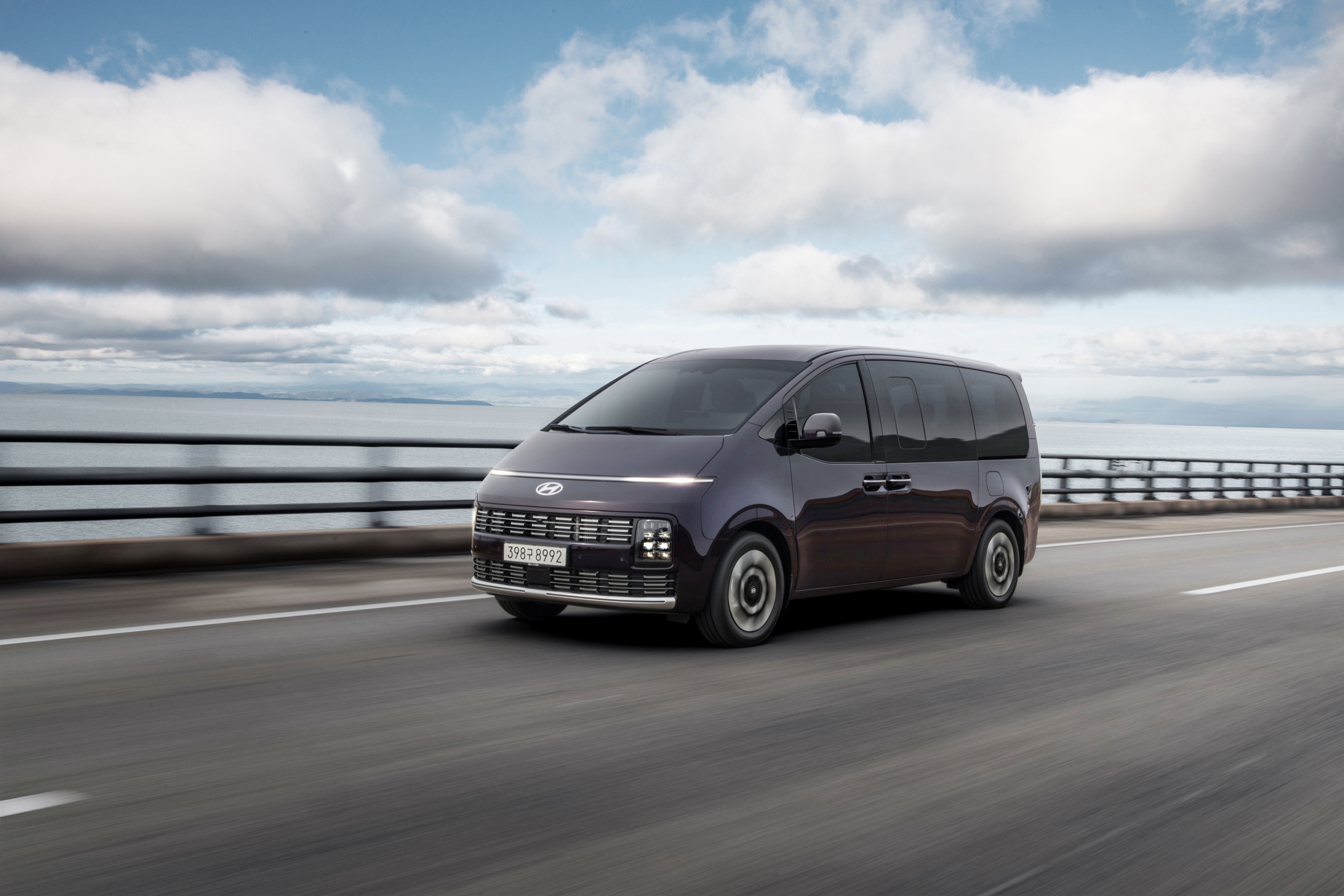 도심의 도로 위를 달리는 더 뉴 현대자동차 스라리아 차량의 전측면