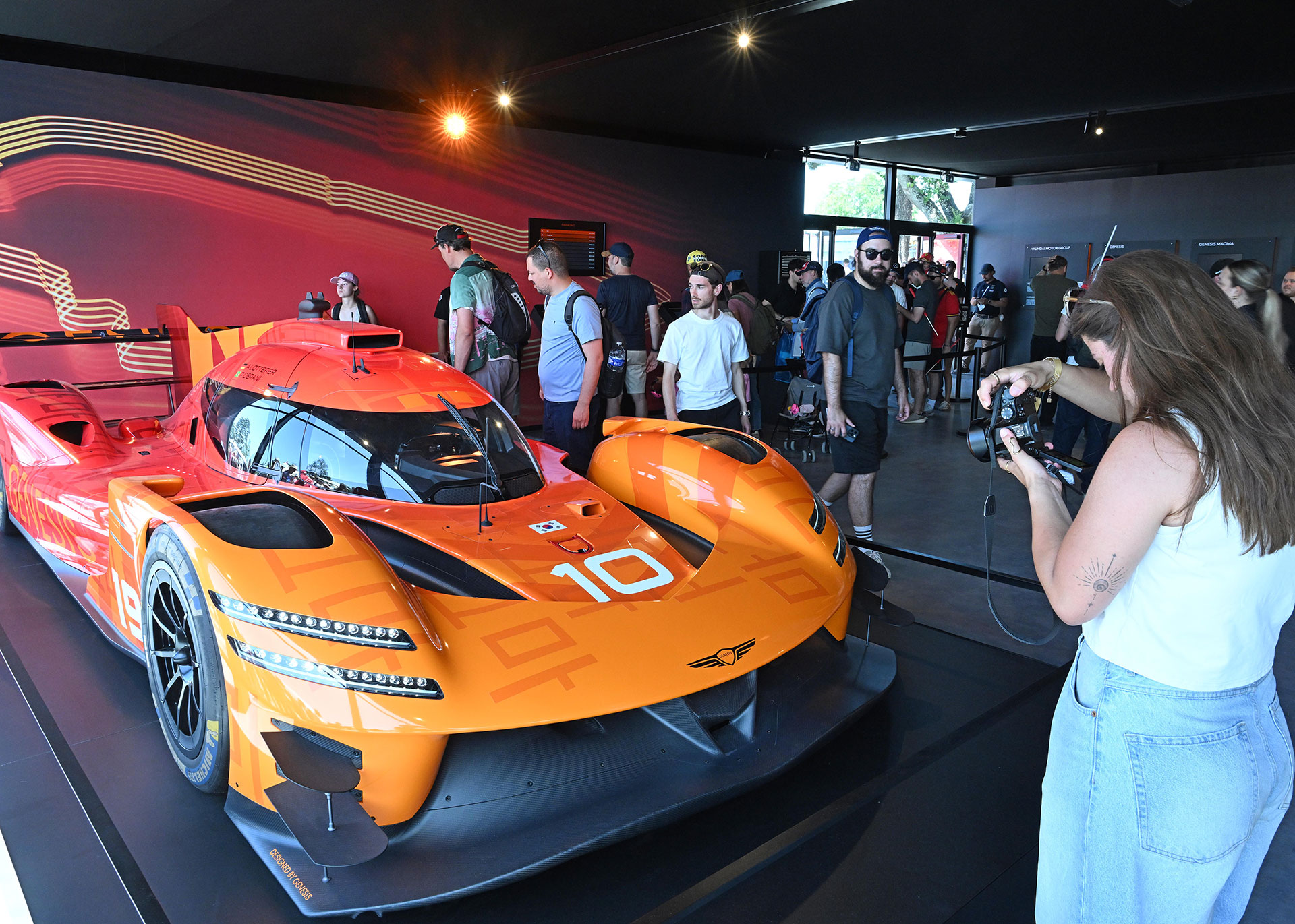 A woman photographing the displayed GMR-001 vehicle.