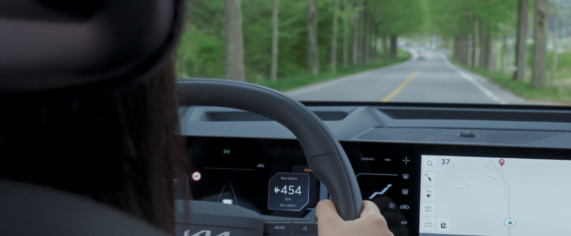 Rear view of a driver behind the wheel of a Kia EV5