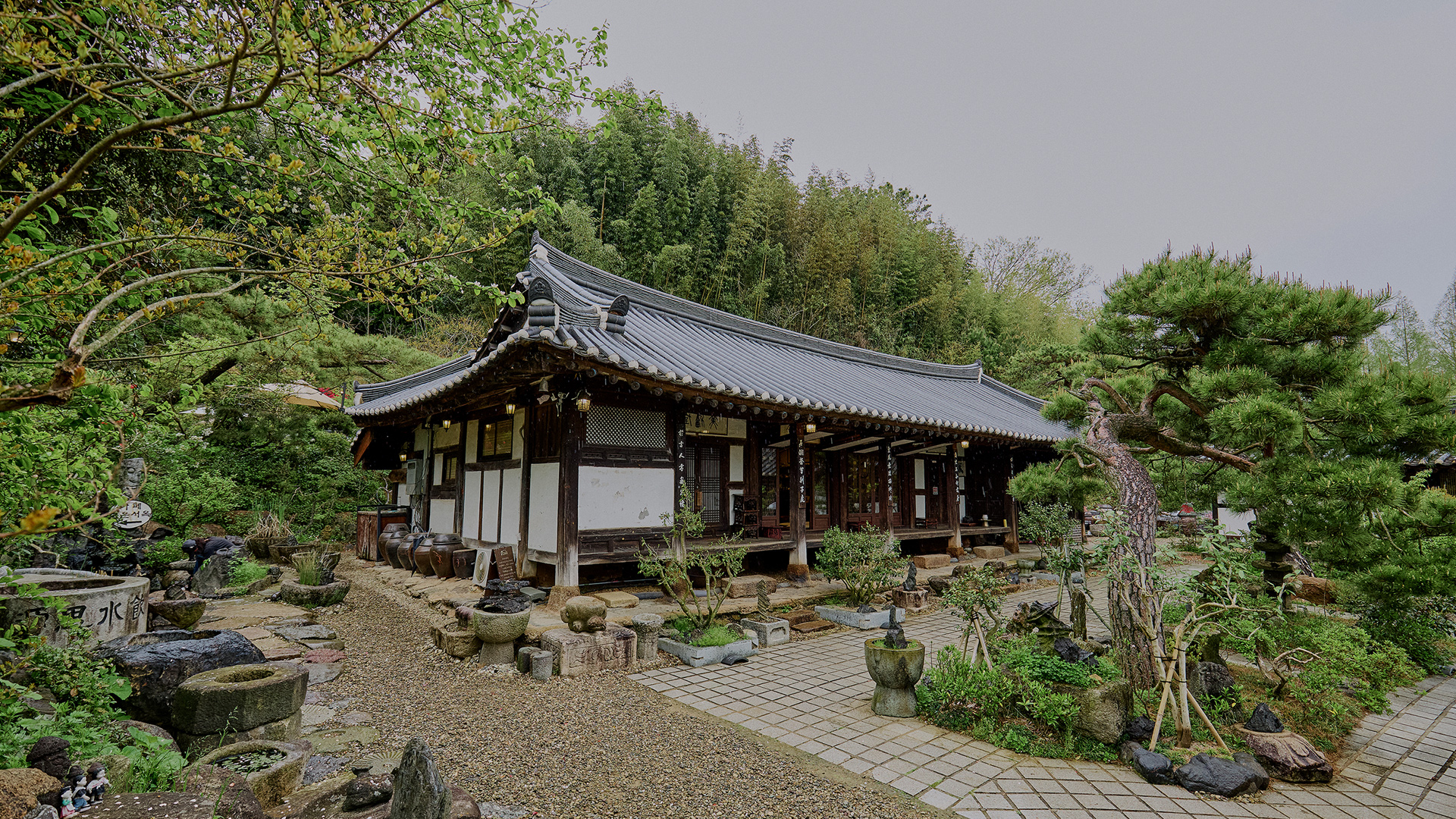 Traditional hanok surrounded by a lush green garden (ChunwunSeook)