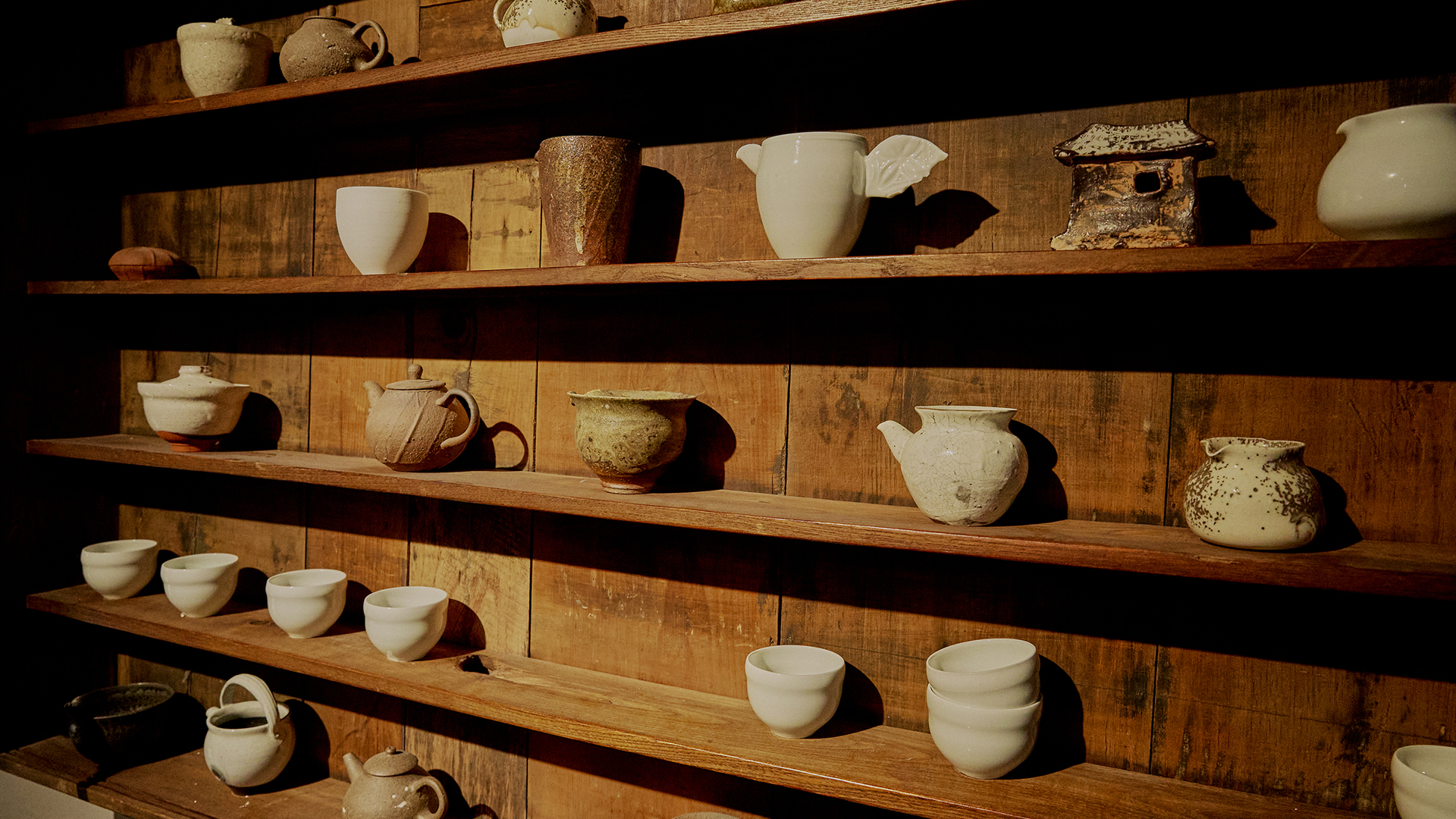 Interior of a pottery workshop with ceramics displayed on shelves