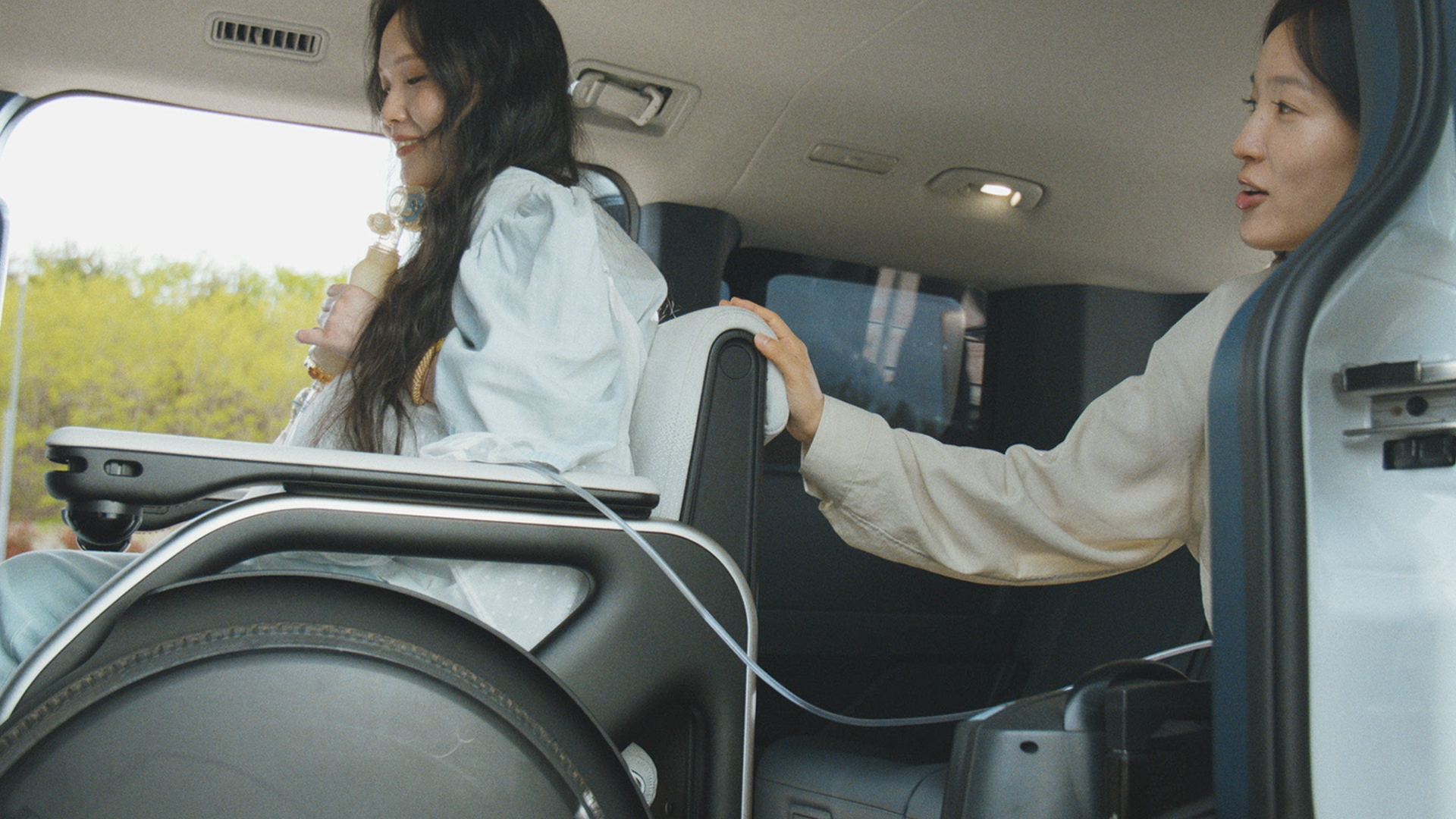 Kim Onyou and his younger sibling riding in the Kia PV5 WAV