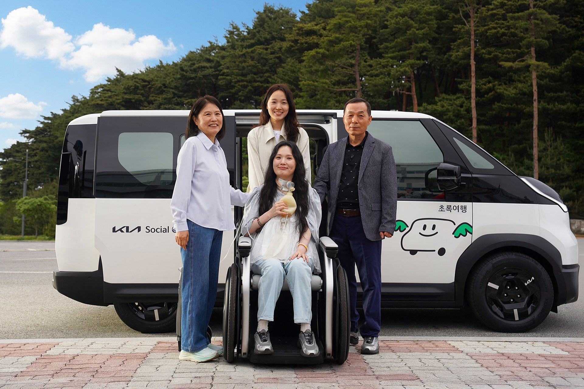A family posing for a photo in front of the Kia PV5 WAV