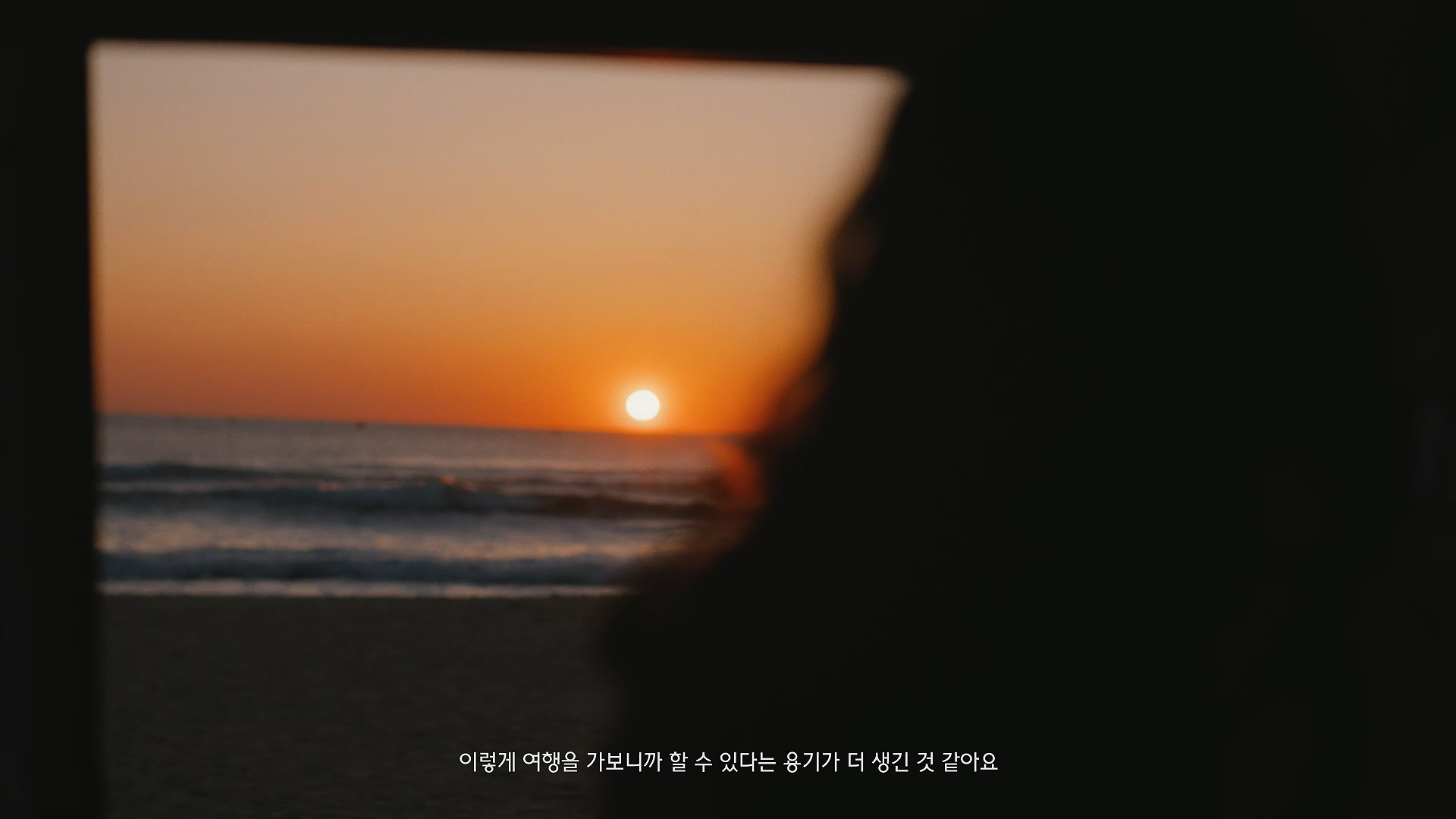 Back view looking out at the sea and sunset (Image text: I feel like I've found courage I didn't know I had.)