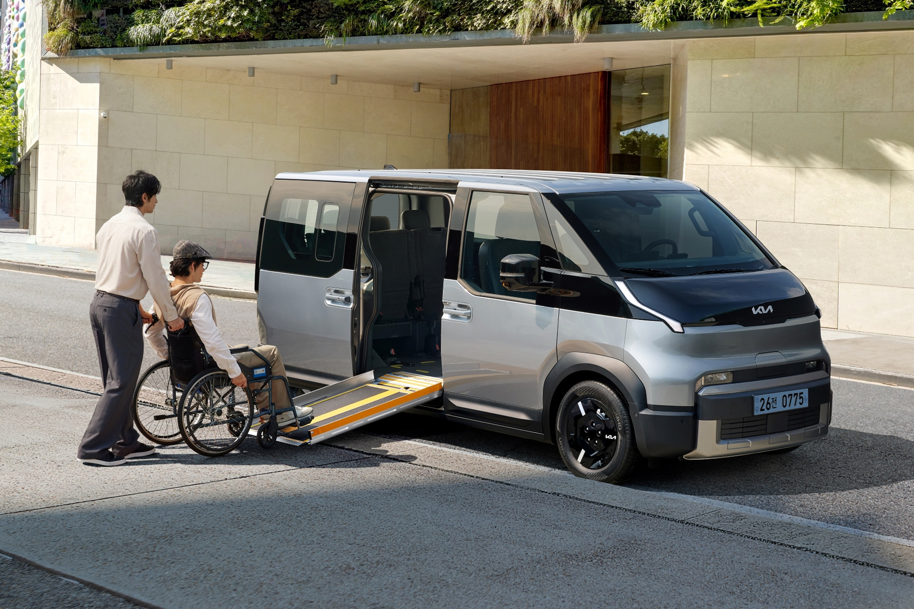 A wheelchair being loaded into the Kia PV5 WAV using the side ramp