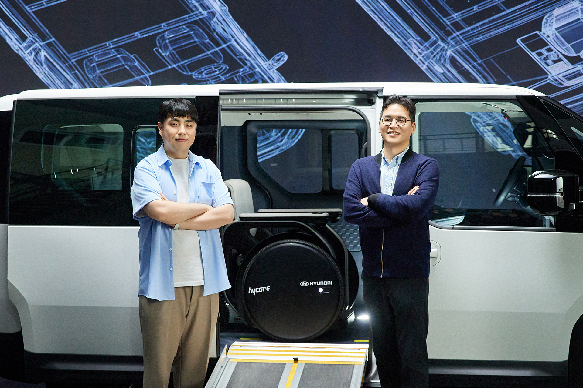 Hansoo Yoo(left) and Jeongho Han(right) posing in front of the Kia PV5 WAV