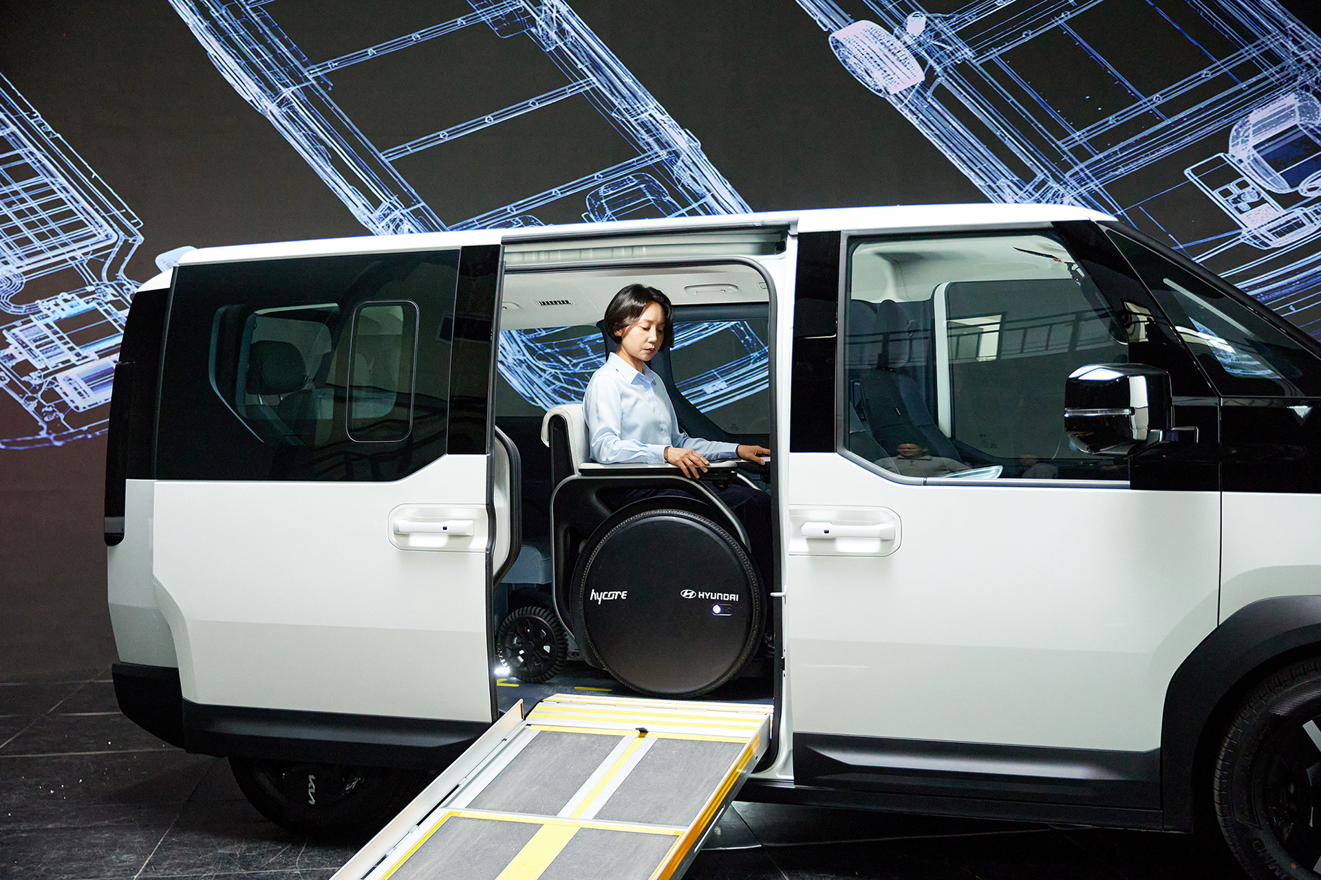 A wheelchair being loaded into the Kia PV5 WAV using the side ramp