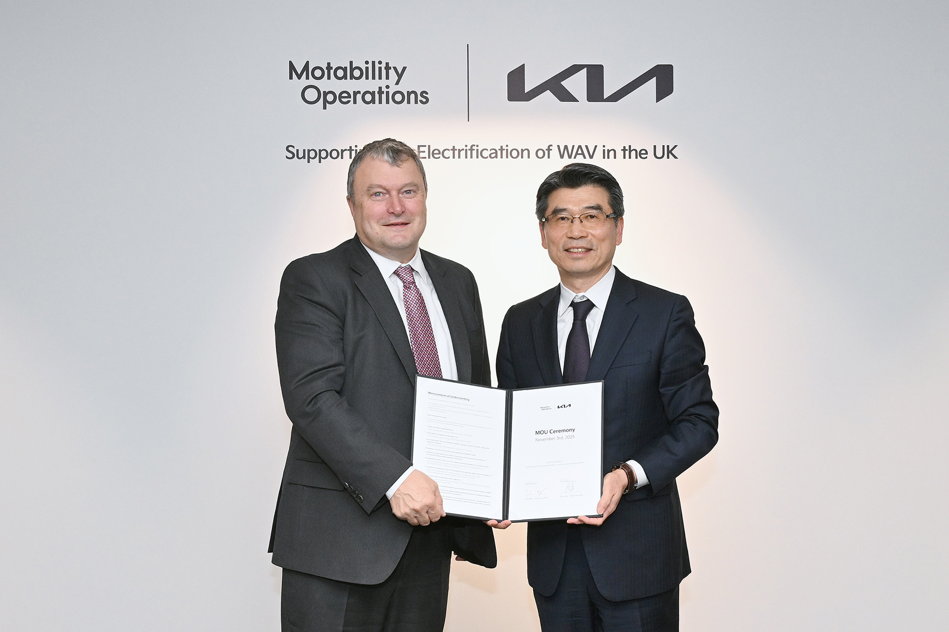 Kia and Motability Operations representatives posing for a commemorative photo after signing a partnership agreement