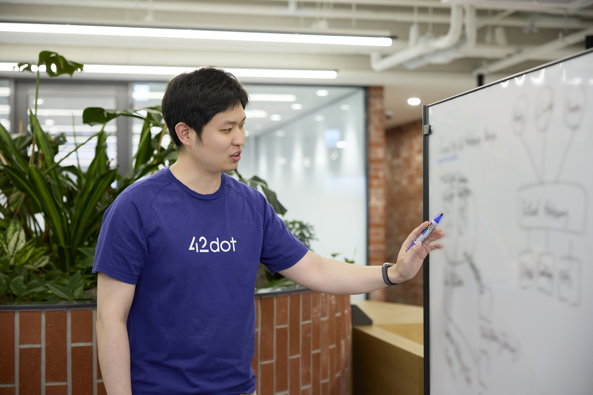 Team Leader Lee Jun-hee's is writing something on the whiteboard